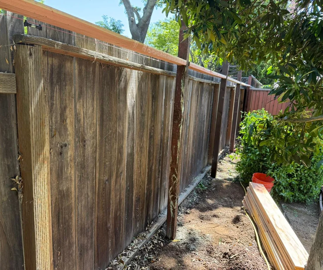 Fence replacement underway: string line pulled, new posts set, milled redwood boards staged